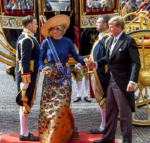 Lavishly dressed royal being helped from a coach.