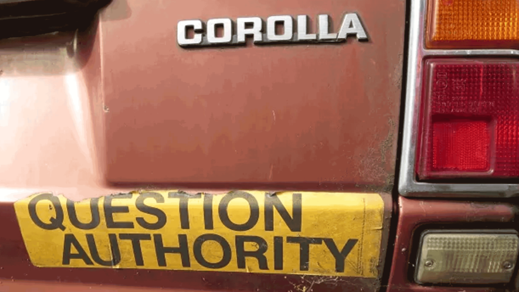 question authority bumper sticker on old car