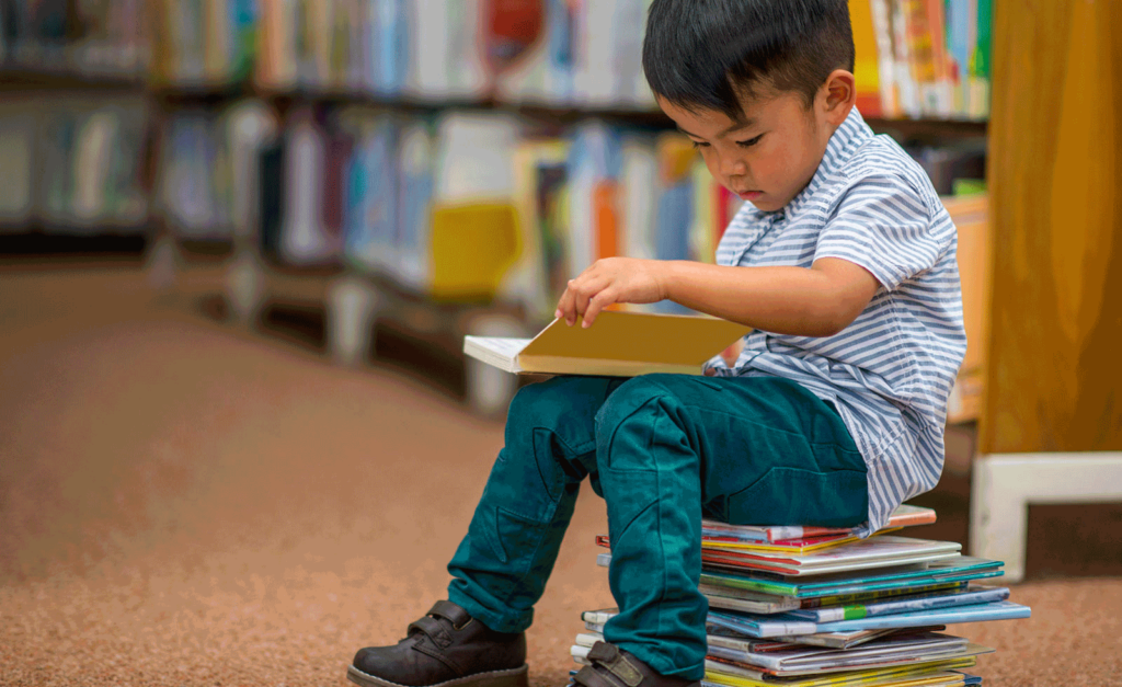 Young boy reading in a library