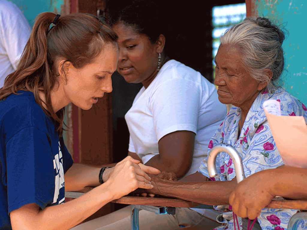 Volunteer healthcare worker helping elderly woman